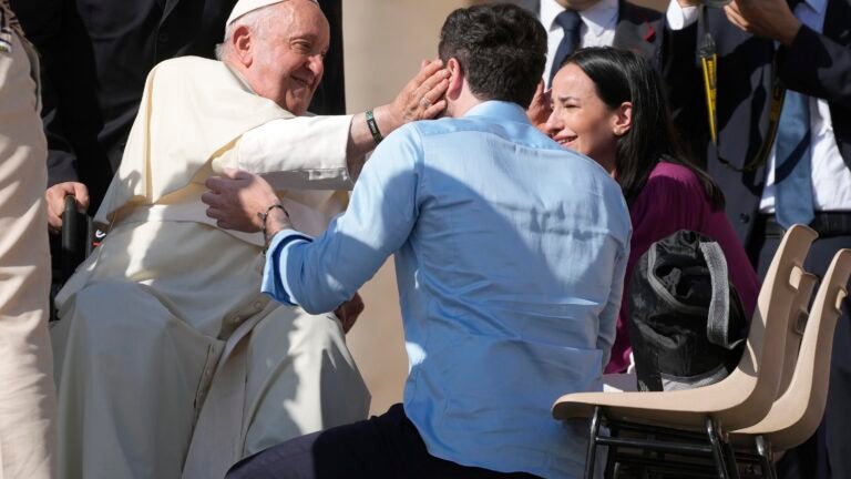 Newlyweds meet with Pope Francis in St. Peter's Square at the Vatican.